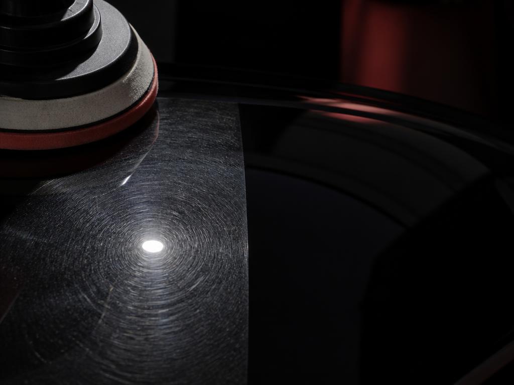 Machine polisher correcting swirl marks on dark paint